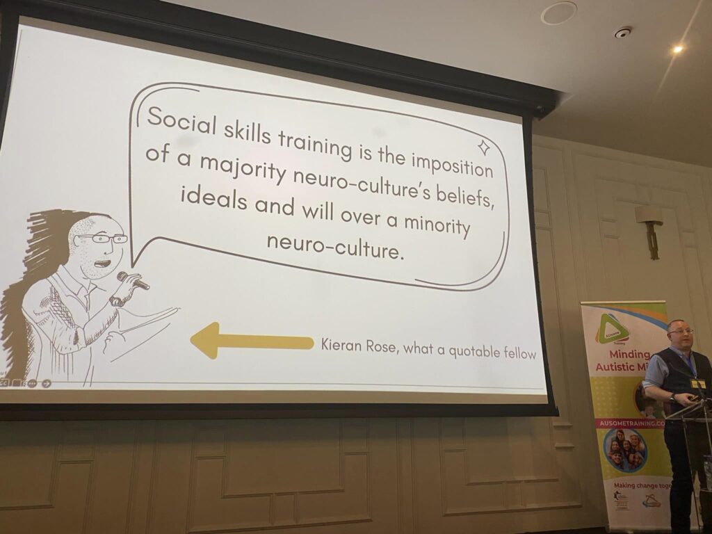 Kieran Rose at Minding Autistic Minds Conference 2024. Their slide reads Social Skills training is the imposition of a majority neuro-culture's beliefs, ideals and will over a minority neuroculture